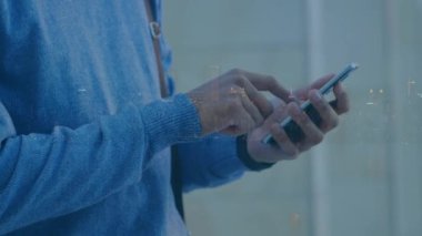 Şehir manzarası üzerinde akıllı telefon kullanan bir adamın animasyonu. küresel iş, iletişim ve finans kavramı dijital olarak oluşturulmuş video.