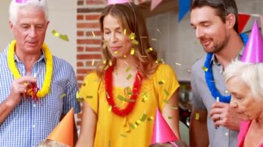 Doğum günü partisinde mutlu bir ailenin üzerine konfetilerin düşüşünün animasyonu. parti, aile ve kutlama konsepti dijital olarak oluşturulmuş video.