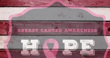 Ahşap arka planda göğüs kanseri metniyle pembe kurdele logosu animasyonu. Göğüs kanseri pozitif farkındalık kampanyası konsepti dijital olarak üretildi.