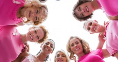 Üzerinde göğüs kanseri metni olan pembe kurdele logosu çeşitli gülümseyen kadınlar grubunun animasyonu. Göğüs kanseri pozitif farkındalık kampanyası konsepti dijital olarak üretildi.