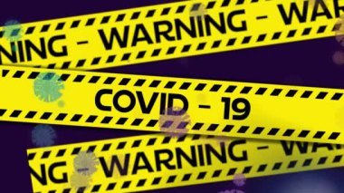 Animation of warning covid 19 text on yellow hazard tape with coronavirus cells, on black. global covid 19 pandemic concept digitally generated video.