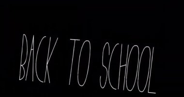 Siyah arkaplan üzerine okula dönüş metninin animasyonu. okul, eğitim ve öğrenim konsepti dijital olarak oluşturulmuş video.