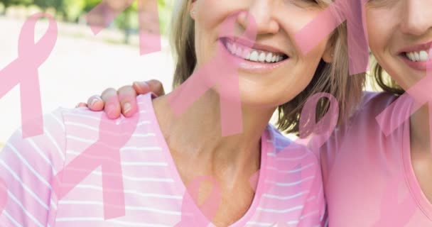 笑顔の女性の多様なグループの上に複数のピンクリボンロゴのアニメーション 乳がん認知キャンペーンのコンセプトデジタル生成ビデオ — ストック動画