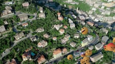 Şehir manzarasının havadan görüntüsüne karşı yüzen çoklu yüz emojilerinin dijital bileşimi. Sosyal medya ağı ve teknoloji kavramı