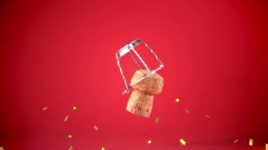 Kırmızı arka planda şampanyaların açılması üzerine düşen konfeti animasyonu. Yeni yıl partisi ve dijital olarak üretilen video konsepti.