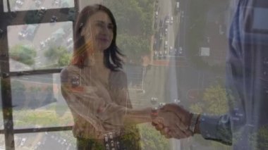 Şehir manzarası üzerinde iş adamı tokalaşmasının animasyonu. küresel iş, başarı ve iletişim konsepti dijital olarak oluşturulmuş video.