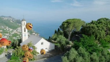 Şehir manzarasının havadan görüntüsüne karşı yüzen çoklu yüz emojilerinin dijital bileşimi. Sosyal medya ağı ve teknoloji kavramı