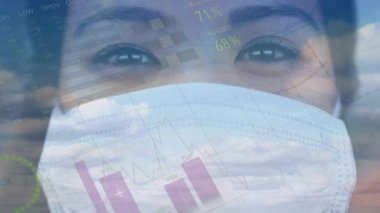 Yüz maskesi takan bir kadının istatistik ve veri işleme animasyonu. küresel covid 19 salgın konsepti dijital olarak oluşturulmuş video.