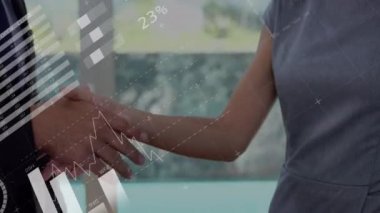 İş adamlarının el sıkışması üzerine istatistik ve veri işleme animasyonu. küresel iş, başarı, bağlantılar ve dijital arayüz konsepti dijital olarak oluşturulmuş video.