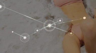 Kumsalda mayo giymiş, güneşlenen beyaz bir kadına karşı bir bağlantı ağı. seyahat, tatil ve teknoloji kavramı