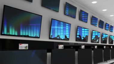 Elektronik mağazasının içinde senkronize video birden fazla televizyon ekranında oynuyor. elektronik ve perakende ticaret teknolojisi kavramı