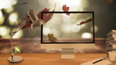 Masaüstü bilgisayar ve ofis ekipmanları sonbahar akçaağaç yaprakları karşısında arka planda kalıyor. Sonbahar sezonu ve teknoloji konsepti