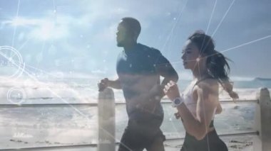 Sahildeki gezinti güvertesinde birlikte koşan karma ırk çiftlerine karşı kurulan bir ağ. Spor, spor ve teknoloji konsepti