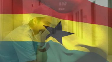 Digital composition of ghana flag waving against stressed caucasian male health worker at hospital. healthcare and medical concept.