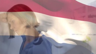 Hastanede stres altındaki beyaz bir kadına karşı dalgalanan Hollanda bayrağının dijital bileşimi. Sağlık ve Tıp Konsepti.