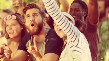 Dışarıda dans eden mutlu insanların üzerine düşen altın konfetilerinin animasyonu. parti ve eğlence konsepti dijital olarak oluşturulmuş video.