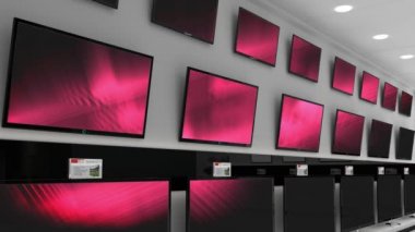 Elektronik mağazasının içinde senkronize video birden fazla televizyon ekranında oynuyor. elektronik ve perakende ticaret teknolojisi kavramı