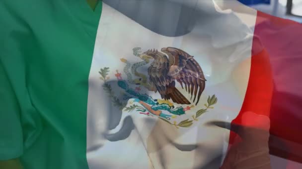 Meksykańska Flaga Macha Przed Starszą Pracownicą Służby Zdrowia Noszącą Maskę — Wideo stockowe
