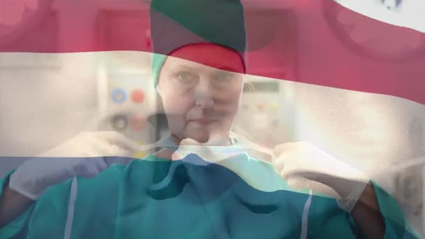 Netherlands Flag Waving Caucasian Female Surgeon Wearing Face Mask Hospital — Αρχείο Βίντεο