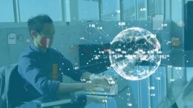 Globe of network of connections and business concept icons against asian man working at office. global networking and business technology concept