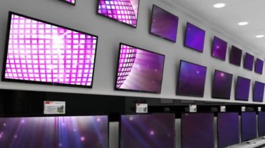 Elektronik mağazasının içinde senkronize video birden fazla televizyon ekranında oynuyor. elektronik ve perakende ticaret teknolojisi kavramı