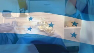 Honduras bayrağı hastanede yüz maskesi takan kadın sağlık görevlisi için sallanıyor. Sağlık ve Tıp Konsepti.