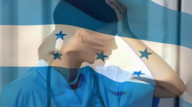 Hastanede stresli Afro-Amerikan kadın sağlık çalışanlarına karşı Honduras bayrağı sallanıyor. Sağlık ve Tıp Konsepti.