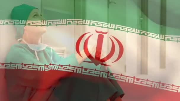 Composición Digital Bandera Irán Ondeando Contra Una Cirujana Caucásica Estresada — Vídeos de Stock