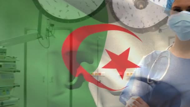 阿尔及利亚国旗挥动着 反对医院里戴口罩的高加索女性保健工作者 保健和医疗概念 — 图库视频影像