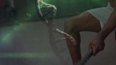 Spor salonunda egzersiz yapan güçlü bir adamın üzerindeki DNA ipliğinin animasyonu. global spor, fitness ve veri işleme konsepti dijital olarak oluşturulmuş video.