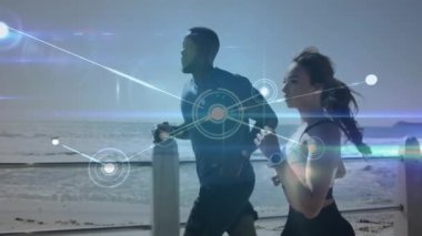 Sahildeki gezinti güvertesinde birlikte koşan karma ırk çiftlerine karşı kurulan bir ağ. Spor, spor ve teknoloji konsepti