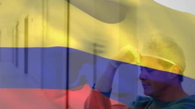 Hastanede stres altındaki beyaz erkek cerraha karşı sallanan Kolombiya bayrağının dijital bileşimi. Sağlık ve Tıp Konsepti.