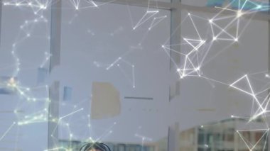 Ofiste kulaklığı olan bir iş kadını üzerinden bağlantı ağının animasyonu. küresel iş, bağlantılar, veri işleme ve teknoloji konsepti dijital olarak oluşturulmuş video.