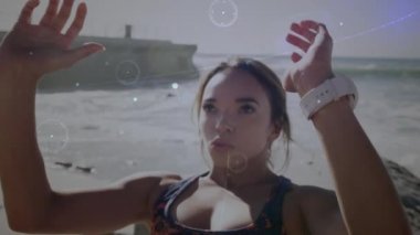 Kumsalda karın kası egzersizi yapan beyaz bir kadına karşı olan bağlantı ağı. Spor, spor ve teknoloji konsepti