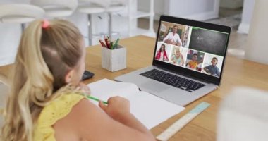 Beyaz kız evde dizüstü bilgisayarla video konferansı yaparken ödev yapıyor. uzak öğrenim ve çevrimiçi eğitim kavramı