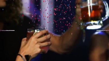 Konfeti ve mor ışık bir grup arkadaşın bir barda içkilerini yudumlarken patlıyor. gece hayatı ve bar partisi konsepti