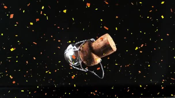 五彩纸屑掉在香槟酒软木塞上 开瓶器掉在黑色背景上 新年晚会与庆祝理念 — 图库视频影像