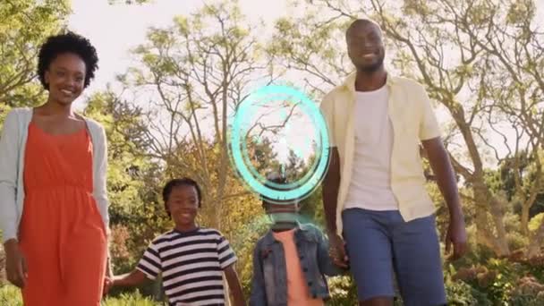 公園を歩いているアフリカ系アメリカ人の家族に対してネオンブルーのデジタル時計 家族愛と団結の概念 — ストック動画