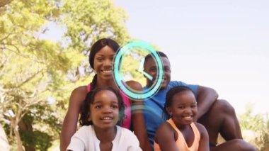 Parkta otururken gülümseyen Afro-Amerikan aile portresine karşı dijital saat işliyor. aile, sevgi ve birliktelik kavramı