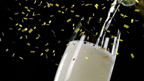 Gouden Confetti Valt Champagne Die Een Glas Tegen Zwarte Achtergrond — Stockvideo