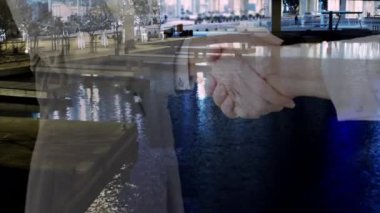 İş adamı ve iş kadınının şehir manzarasına karşı el sıkışması. iş ortaklığı ve teknoloji kavramı