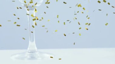 Zeytinlerin üzerine düşen altın konfeti gri arka planda kokteyl bardağına düşüyor. gece hayatı ve bar partisi konsepti