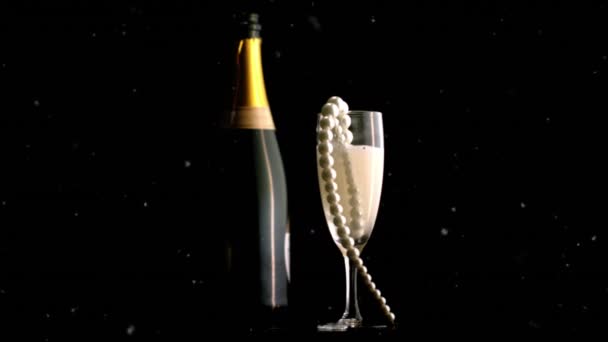 Bílé částice perleti na sklenici šampaňského a láhev šampaňského na černém pozadí. nový rok předvečer párty a oslavy koncept