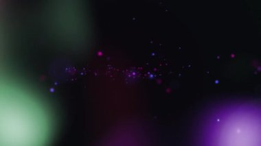 Siyah arkaplanda hareket eden renkli parçacıkların ve bokeh ışıklarının animasyonu. hareket, enerji ve bağlantı arka plan kavramı dijital olarak oluşturulmuş video.