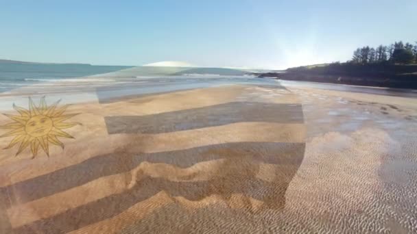 晴れたビーチや海の上に吹くウルグアイの旗のアニメーション 愛国心独立お祝いのコンセプトデジタルで生成されたビデオ — ストック動画