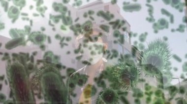 Yüz maskeli bir kadının üzerinde hareket eden kovid 19 hücrenin animasyonu. küresel covid 19 salgın hastalık ve sağlık hizmetleri konsepti dijital olarak oluşturulmuş video.