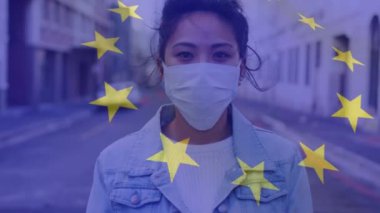 Yüz maskesi takmış bir kadının bayrağını dalgalandırmak. küresel covid 19 salgın hastalık ve sağlık hizmetleri konsepti dijital olarak oluşturulmuş video.