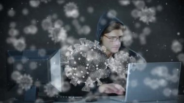 Kapüşonlu kapüşonlu bir adamın dizüstü bilgisayar kullanarak üzerinde kovid19 hücrenin animasyonu. covid 19 salgını sırasında küresel siber virüs ve çevrimiçi güvenlik