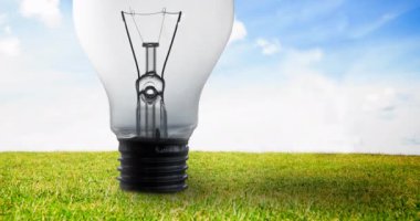 Mavi gökyüzü ve çimenlerin üzerindeki ampulün animasyonu. küresel koruma ve yeşil farkındalık kavramı dijital olarak oluşturulmuş video.