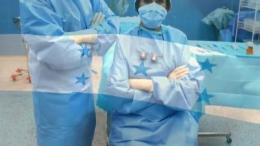 Yüz maskeli cerrahların üzerinde sallanan Honduras bayrağının animasyonu. küresel covid 19 salgın hastalık ve sağlık hizmetleri konsepti dijital olarak oluşturulmuş video.